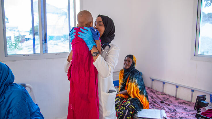 Dr. Fahmo holds a young patient close.