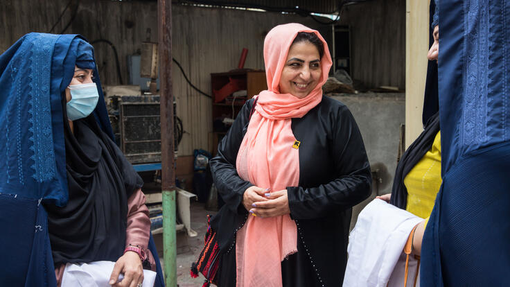 Dr, Najia stands and discusses with two staff from her mobile health team.