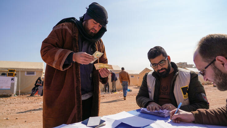 Man receives cash support from IRC staff in northern Syria.