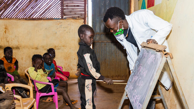 An early grade student, actively learning how to read and spell words in a literacy class.