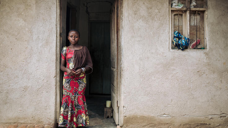 Christelle stands in the entrance to her home.