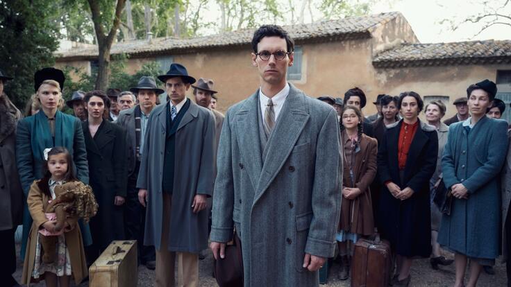 Still from Netflix series "Transatlantic"- Cory Michael Smith (playing Varian Fry) is center, surrounded by other cast members.