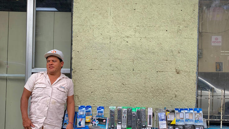 Dennis stands beside his sales booth.