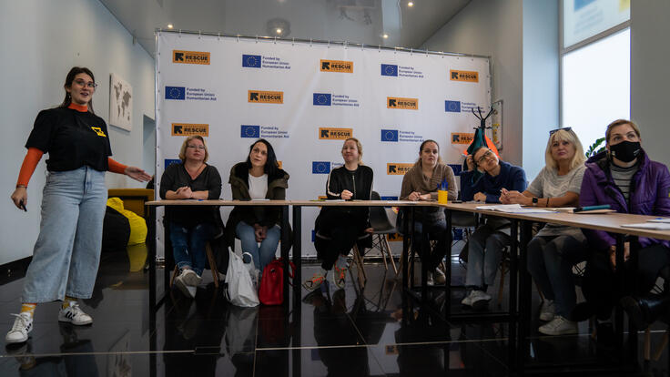 Women sit around a table during an English language class.