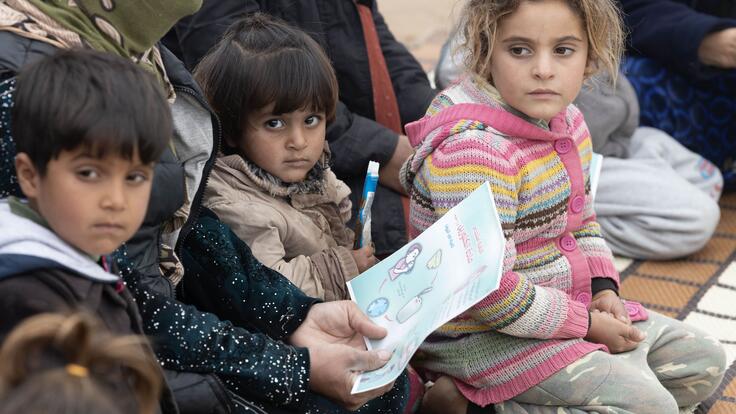 Children and their parents carefully listen to the health education session given at the camp. 