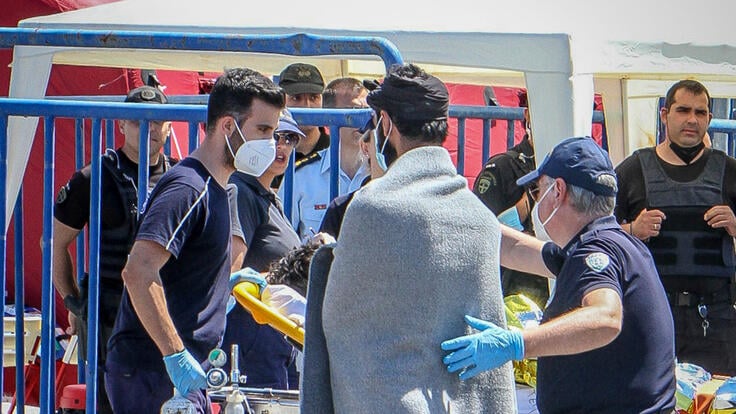 A medic escorts a survivor, after a boat carrying dozens of migrants sank in international waters in the Ionian Sea, at the port in Kalamata town, on June 14, 2023.