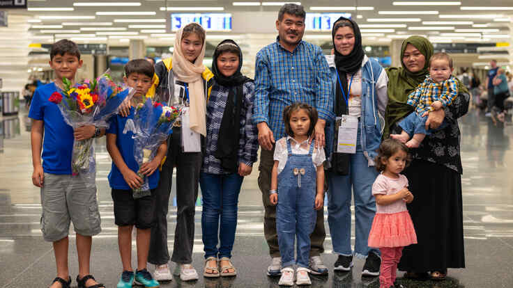 The Hussaini family stand in line facing the camera.