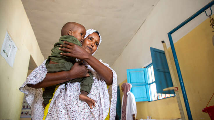 A mother holds her child close as the two walk through a malnutrition treatment ward in the Hanano Hospital in Somalia.