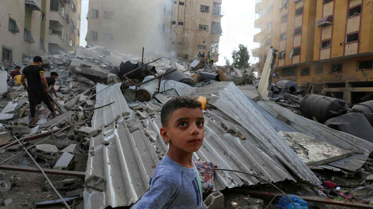 People assess the destruction cause by Israeli air strikes in Gaza City on October 7, 2023.