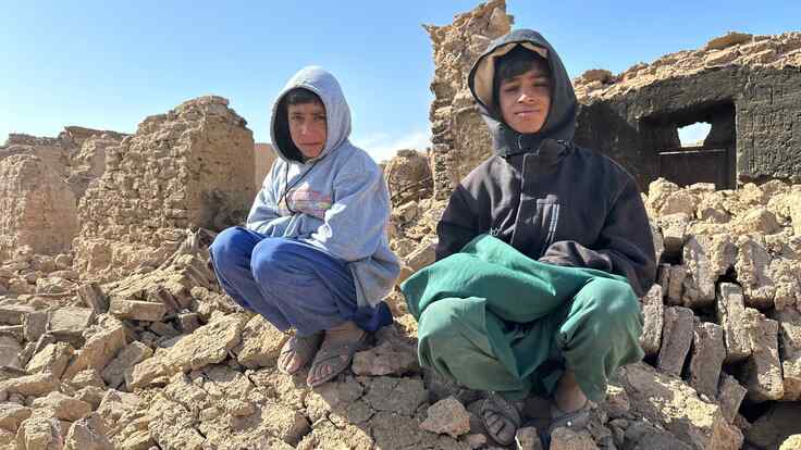 Two boys sit atop a pile of rubble from a building that was destroyed by an earthquake that struck near Herat, Afghanistan.