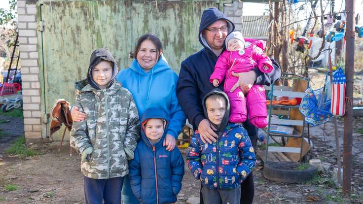 Olena and her family standing outside