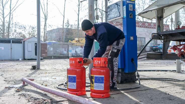 An IRC worker fills up tanks of gas to be distributed to clients