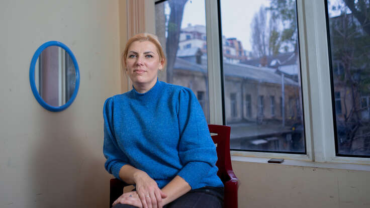 En kvinna sitter i Ukraina och tittar in i kameran.