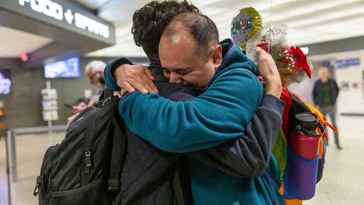 Two family members embrace after finally being reunited at an airport in the U.S.