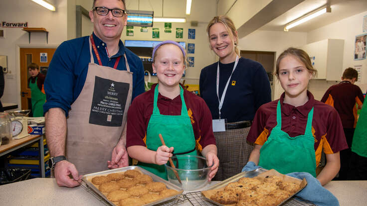 Romola Garai with students and their teacher at a school participating in the Healing Classrooms program