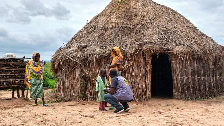 An IRC health worker treats a child outside of their home in northern Cameroon.