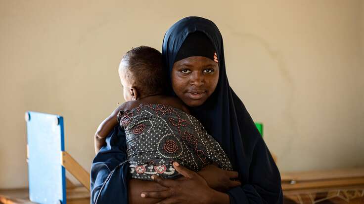 Shukri a Sudanese refugee in Kenya is holding her child 
