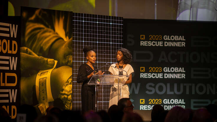 Two people speak onstage at the IRC's Global Rescue Dinner.