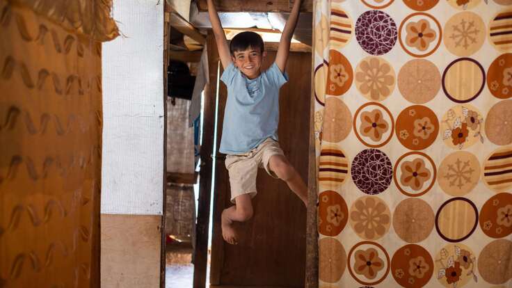 Osam klettert zu Hause auf den Holzbalken, die das Zelt stützen.