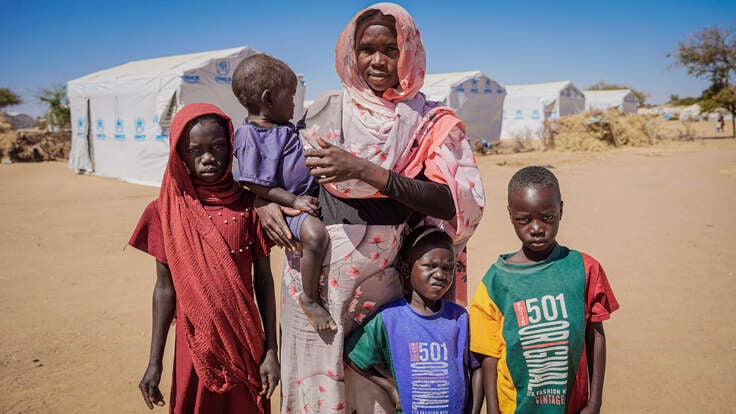 Bousseina poses for the photo, surrounded by her children.