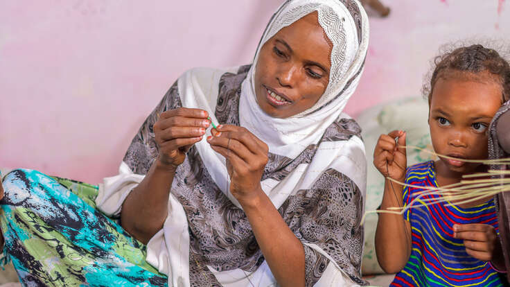 Iftu und Fidiya im Frauenzentrum, wo Iftu lernt, traditionelle Körbe zu flechten, die sie auf dem lokalen Markt verkaufen kann.
