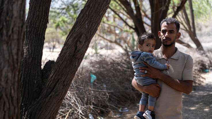 Nader carries his son Aws.