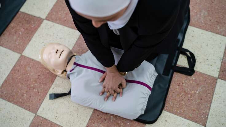 A first aid trainer teaches CPR techniques to attendees. 