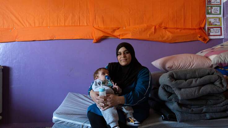 Warda poses for a photo while holding her young son, Mohammad.