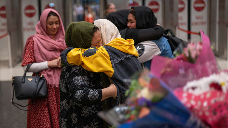 Två familjemedlemmar kramar om varandra på en flygplats