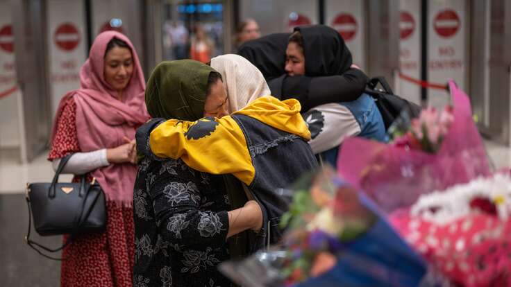 Afghan refugee family embraces after reuniting in the U.S. with support from the IRC