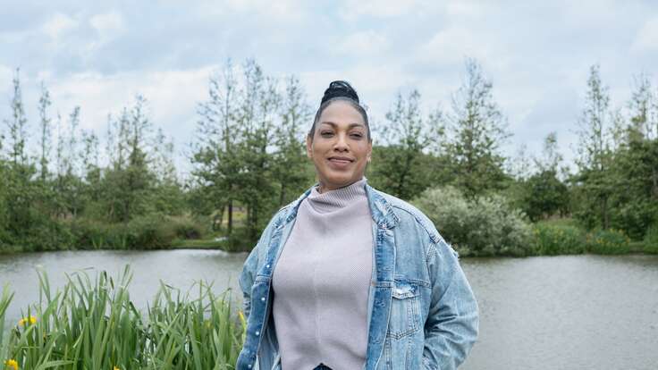 Casey, a refugee in London, stands by a lake after IRC employment and well-being support.