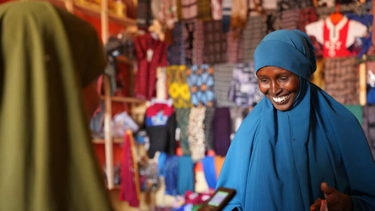 A woman buys fabric in a shop