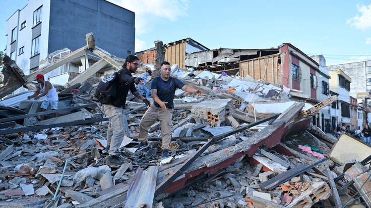 People and rescuers search for victims amid debris of a collapsed building at the city center after a magnitude 7.4 earthquake struck Colombia. 