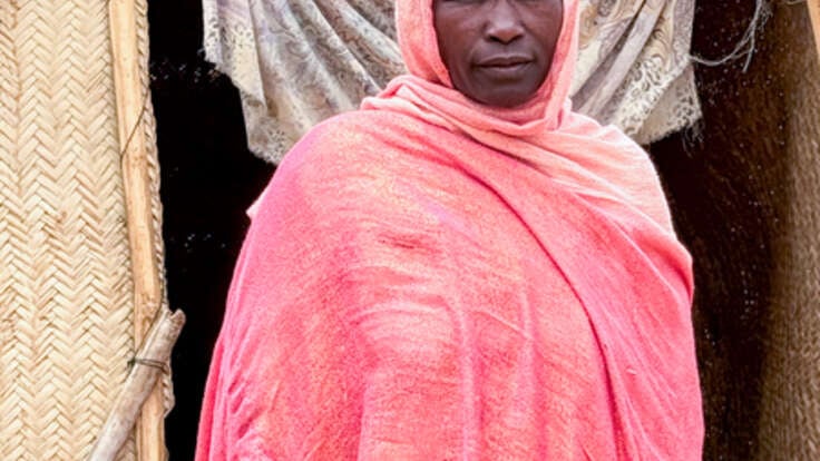Hawa (45), poses for a photograph outside her shelter.