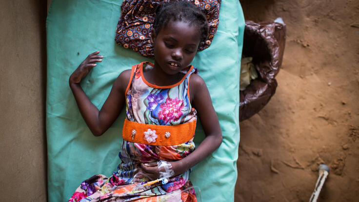 An eight-year-old Somali girl, Falastine, lies in a hospital bed with an intravenous drip as part of her treatment for severe dehydration.  