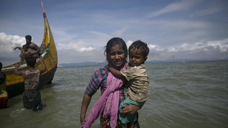 A Rohingya mother carries her baby to shore in Bangladesh from the boat that brought them and other Rohingya Muslim refugees from Rakhine State in Myanmar. 