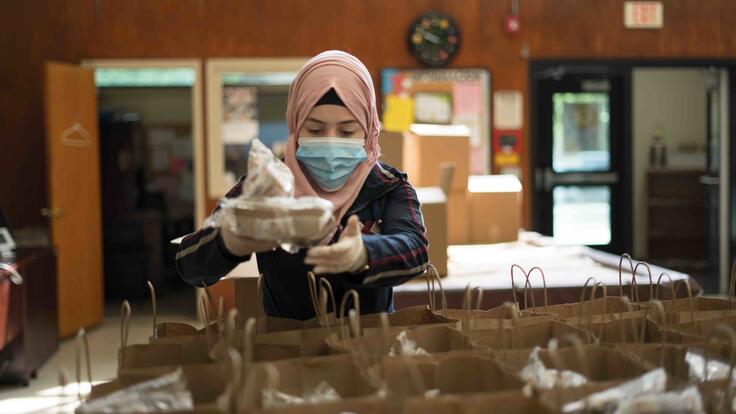 Refugee Rania Abou from Damascus, Syria distributes meals to people experiencing food insecurity in New Jersey, USA during the COVID-19 pandemic. 