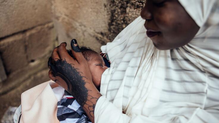 A woman, Hussaini, feeding newborn baby Bello