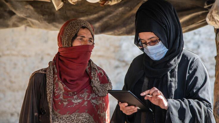A woman living in Ghaibi Bala camp in Kabul, Afghanistan is interviewed by International Rescue Committee staff to see if she meets the criteria to receive a cash distribution from the IRC.