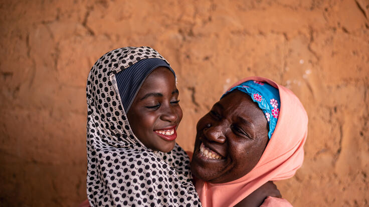 8-year-old Fatima embraces her mother, Habiba, while getting ready to go to school. 