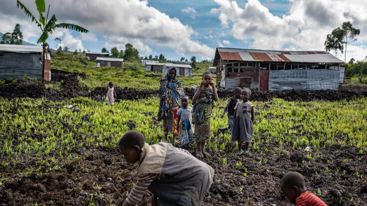 Woman and children work in fields in an area of the Democratic Republic of Congo affected by an Ebola outbreak