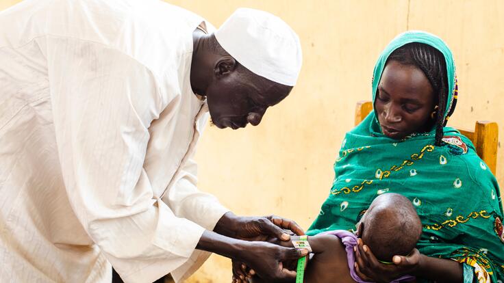 A mother holds her baby during an exam for acute malnutrition at an International Rescue Committee supported health center in Chad. 