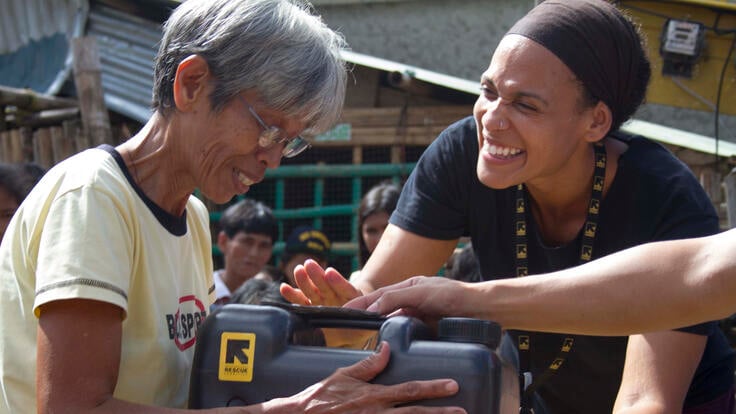 IRC aid worker Aisha Bain distributing emergency supplies to people affected by Typhoon Haiyan.