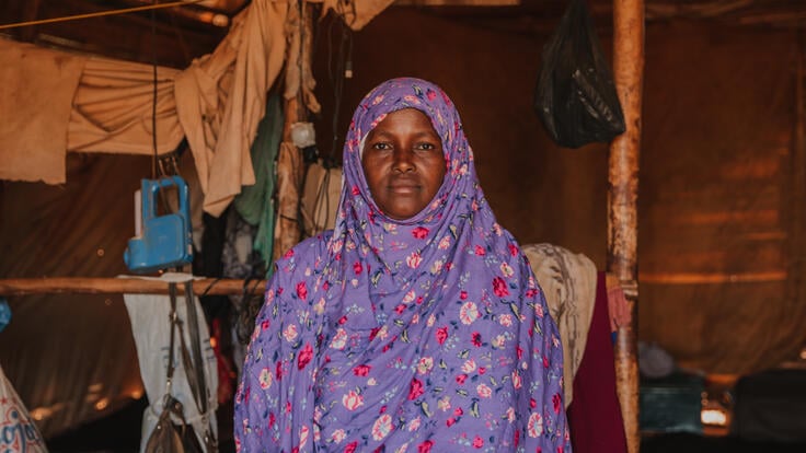 Halima Hashi, a 37-year-old woman from Somalia, stands inside a dim shelter in the refugee camp where she now lives in Ethiopia.