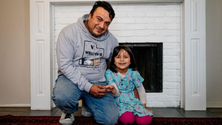 Father hugging his daughter beside the fireplace