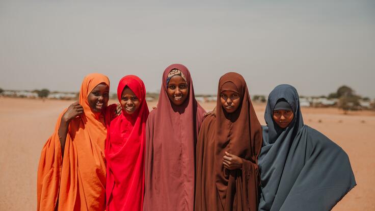 Five young women standing next to each other