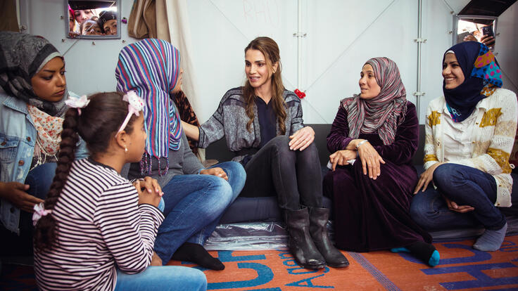 Queen Rania Al Abdullah of Jordan sitting with members of the Kara Tepe refugee site.