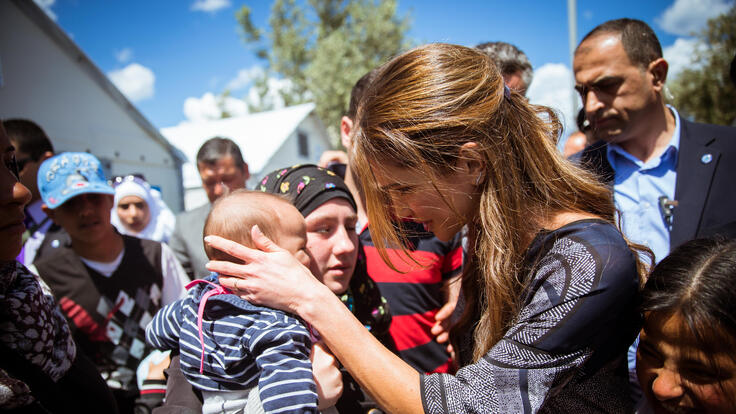 Queen in Rania speaking to a woman and her infant.