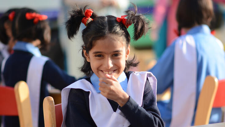 A young girl smiling at the camera.