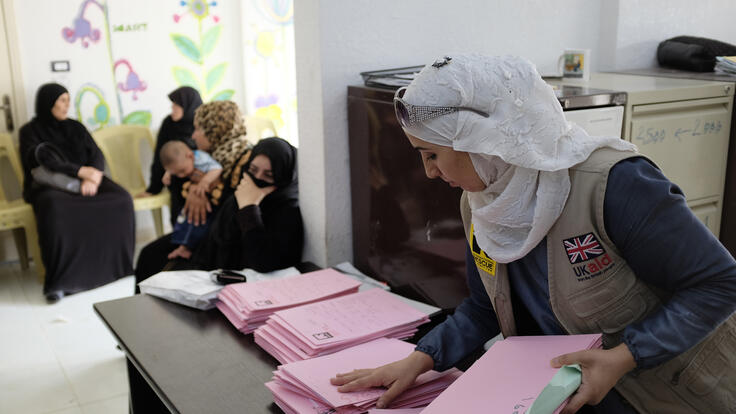 Amira preparing patient files and helping visitors identify the documents they need for treatment.